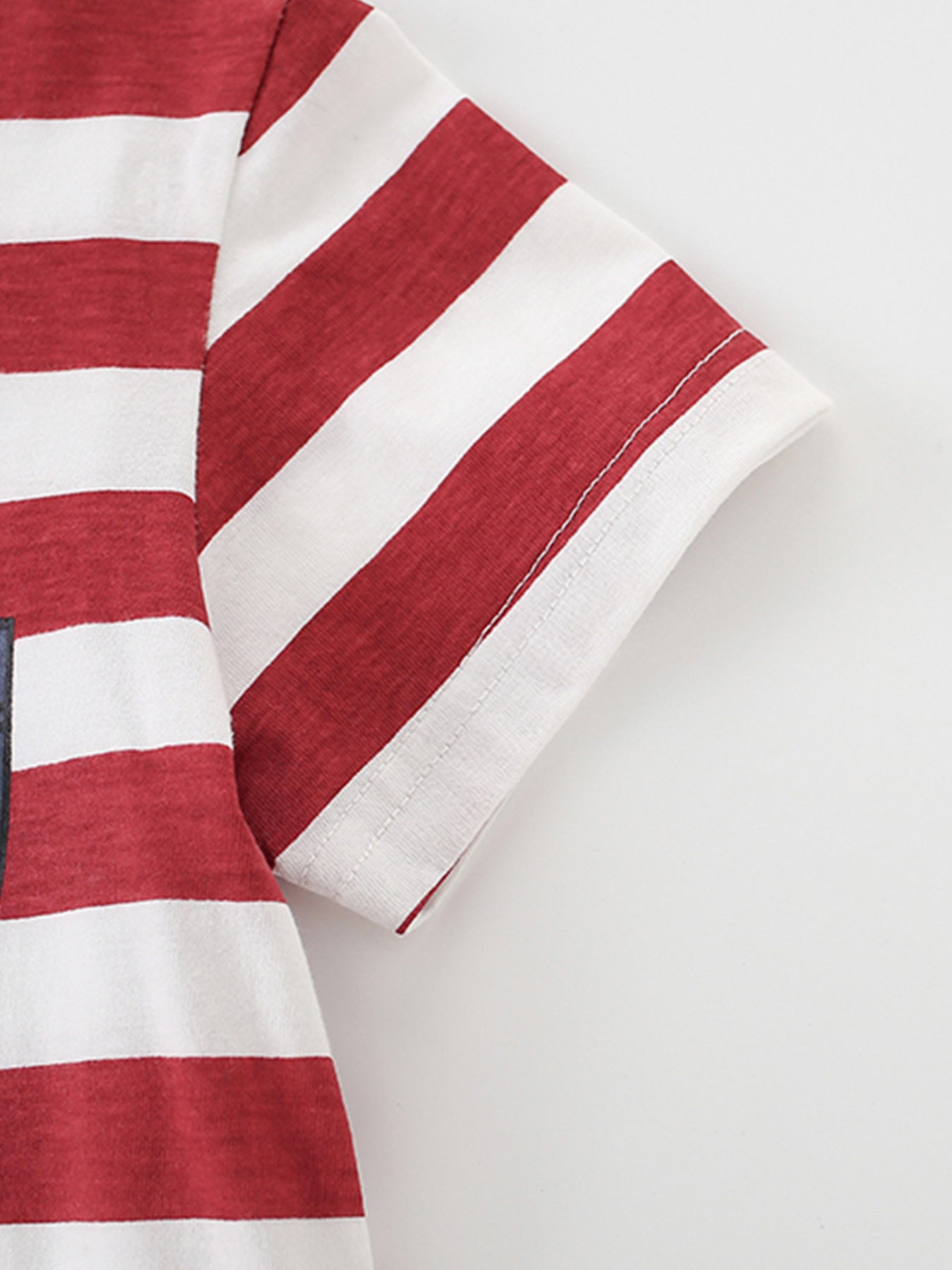Close-up of the striped short sleeve hem and stitching on the children's t-shirt