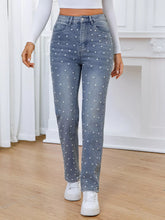 Women's high-waisted straight-leg jeans with pearl embellishments and pockets.