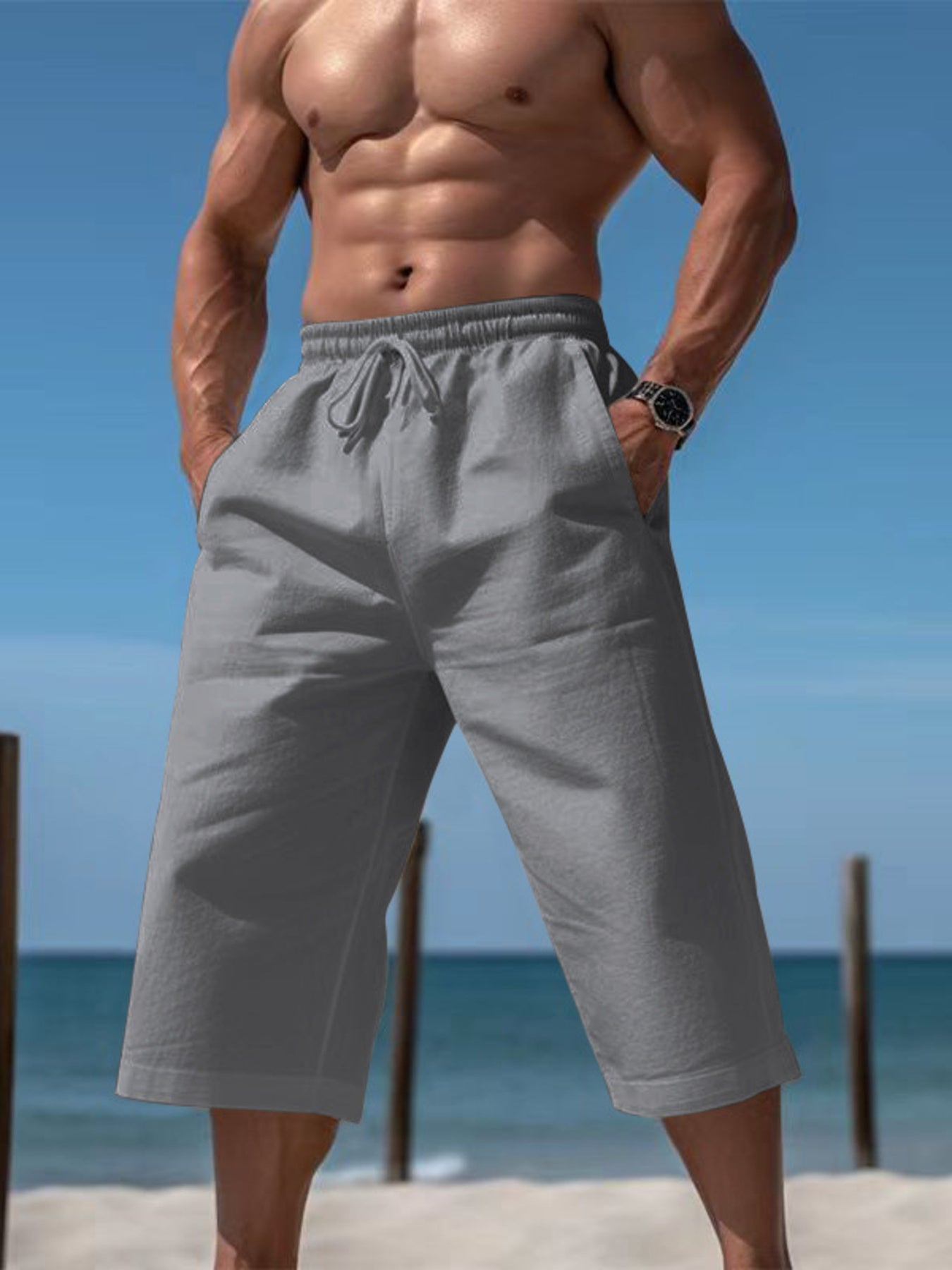 Men's grey cropped casual pants with a drawstring waist and pockets.