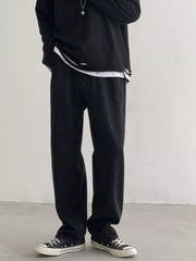 Men's Black loose fit wash jeans on model, front view with black top.