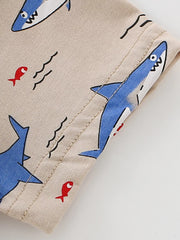 Close-up of sleeve hem stitching and shark print detail on tan children's tee