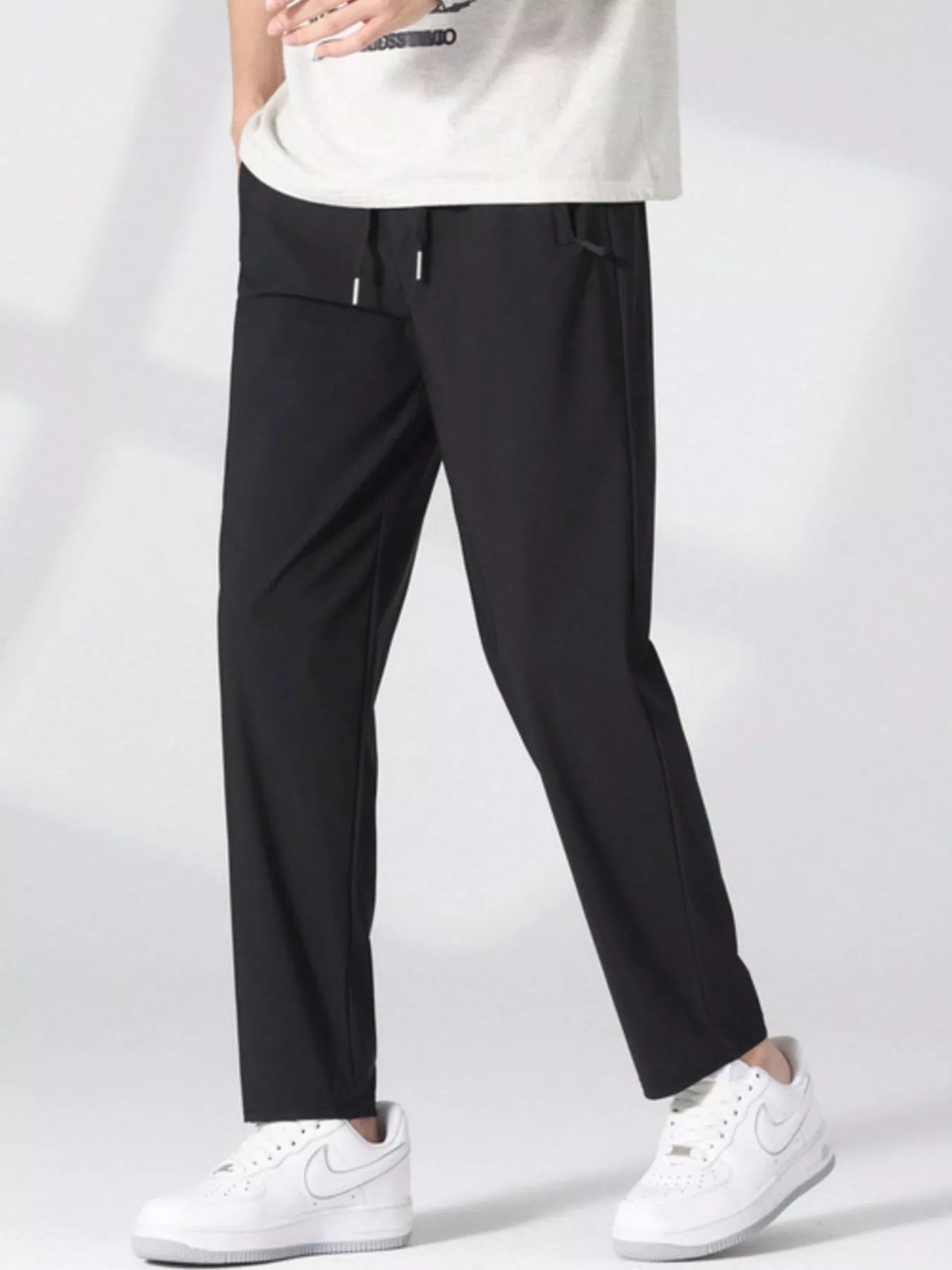 Men's black lightweight casual pants with a drawstring waist and pockets.
