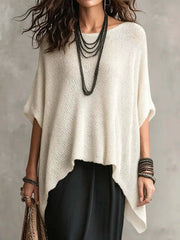Front view of a loose white open knit cover-up with an asymmetrical pointed hem