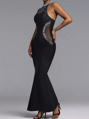 Three quarter view of black sleeveless maxi dress showing sheer waist panel and pearl trim
