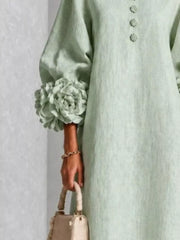 Close detail of the sage midi dress sleeve with a large floral cuff and small floral front buttons