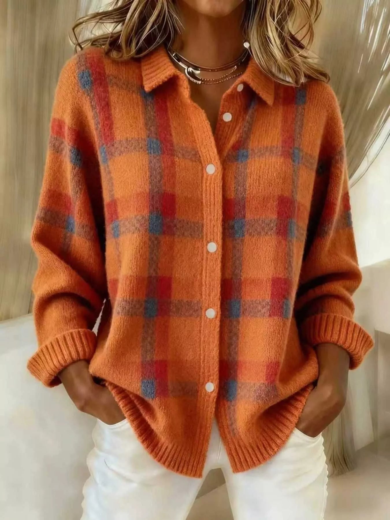On-model front view of an orange and red plaid button-down knit cardigan with long sleeves