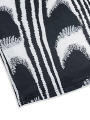 Close view of the hem and abstract print on a black and white sleeveless bodycon maxi dress