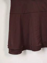 Brown mini dress skirt detail showing tiered hem and smooth fabric
