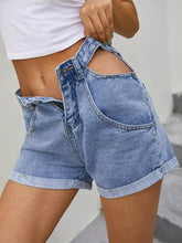 Women's blue high-waisted denim shorts with cutout details and pockets.