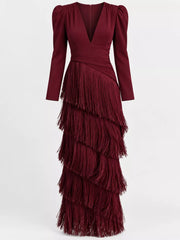 Front studio view of a burgundy fringed maxi dress with puff sleeves and tiered fringe