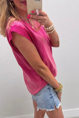 Side view of a pink mineral wash top with lace-trim cap sleeves and raw seam details.