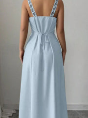 Close back view of light blue maxi dress showing tied waist and patterned straps