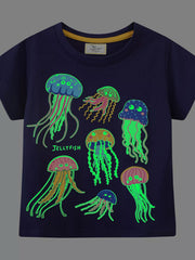 Front view of black children's tee in the dark with glowing green jellyfish graphic
