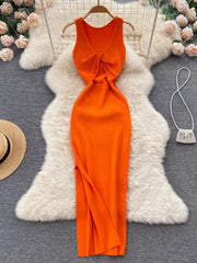 Orange sleeveless knit bodycon midi dress, back view with knotted open back on hanger
