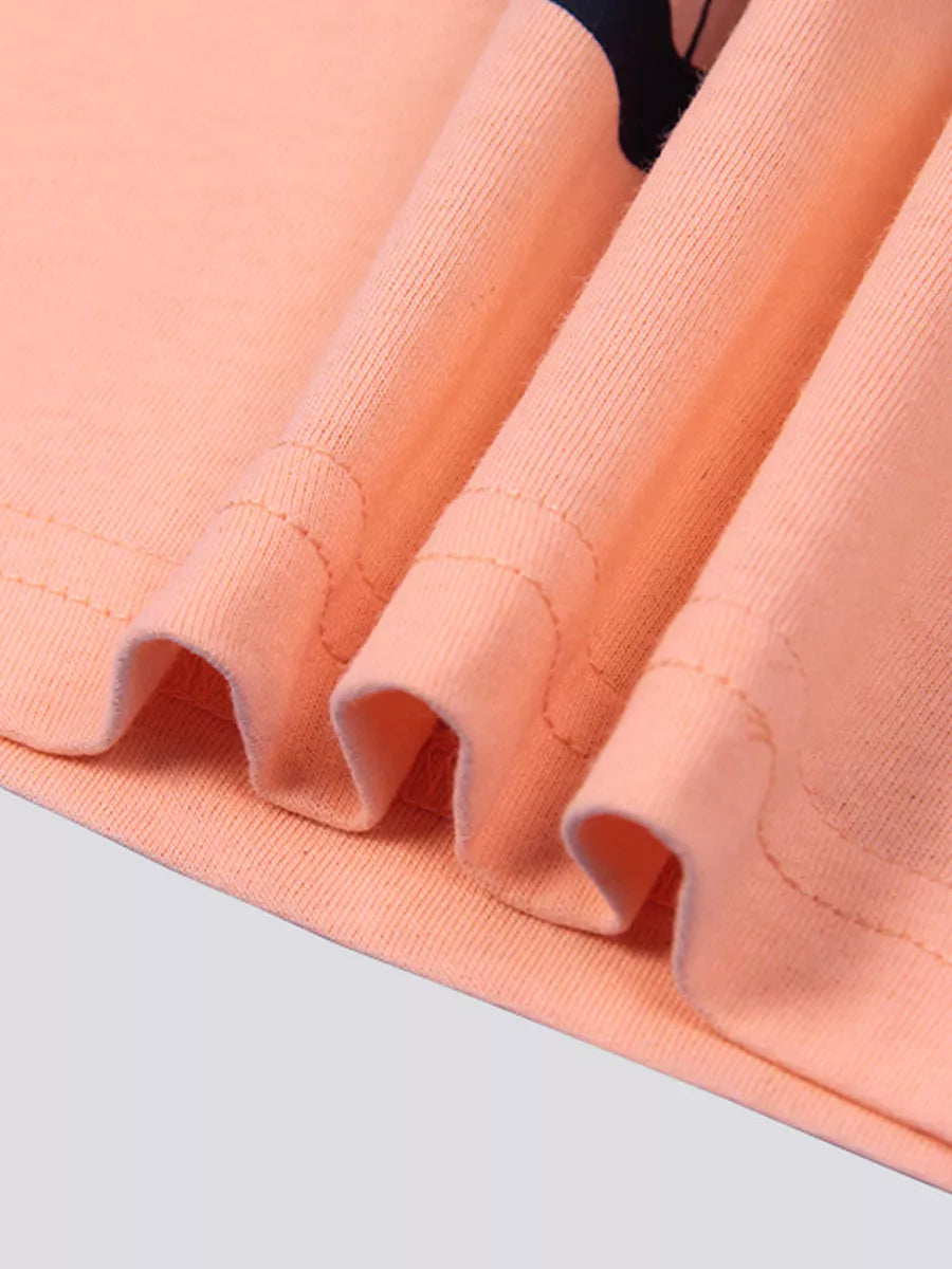 Close up of the folded pink fabric and stitching at the hem of the T-shirt