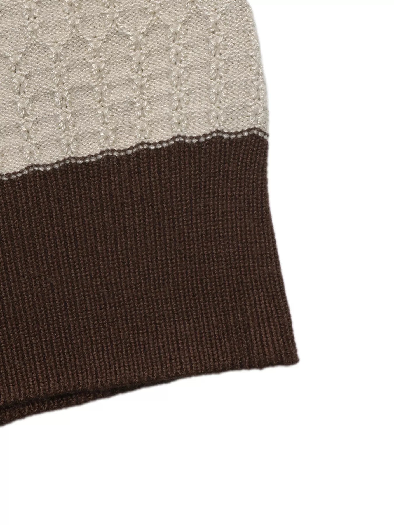Close up of the cream textured stripe meeting the brown ribbed hem on the top