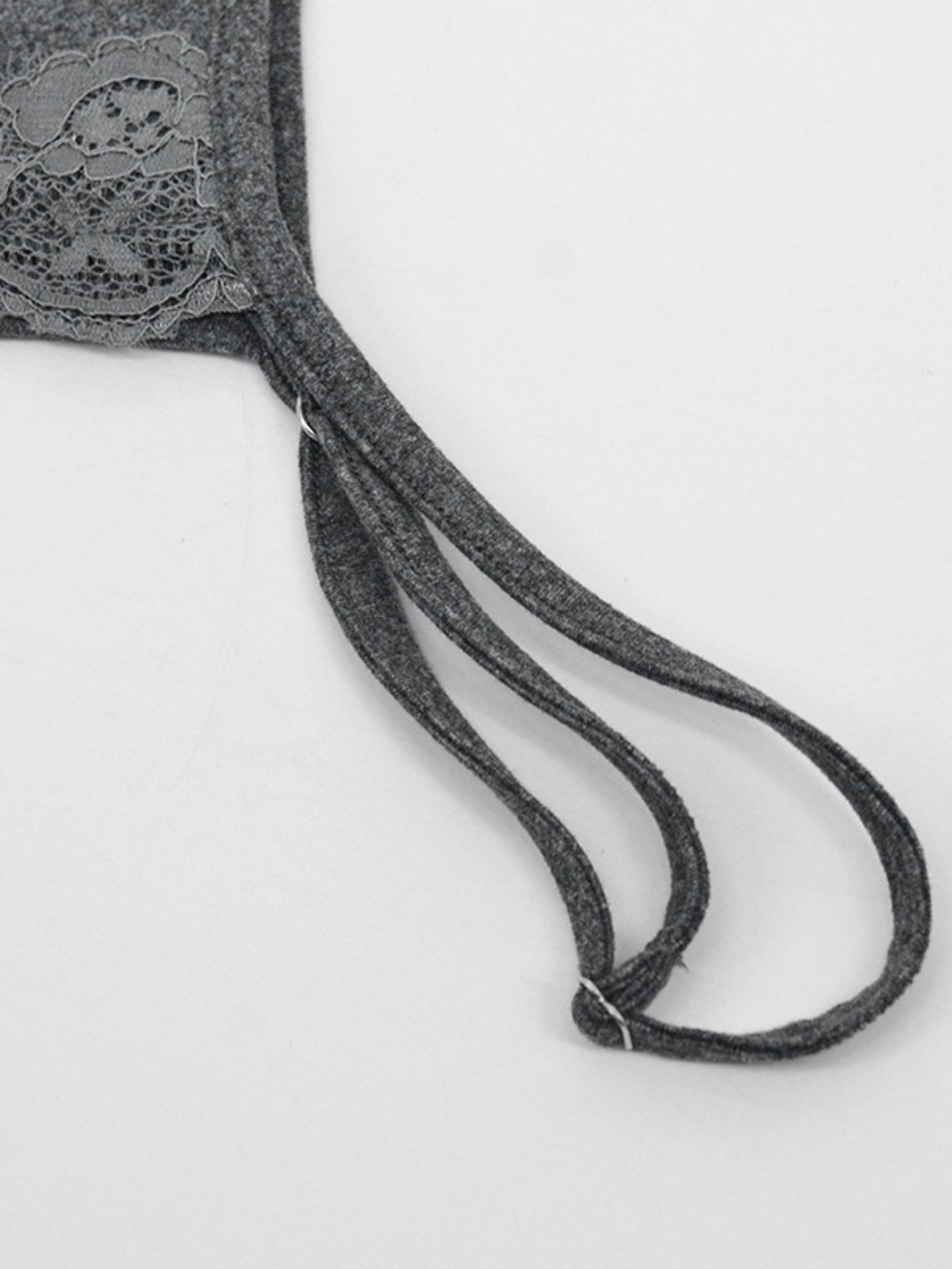 Close view of grey thin strap and lace detail on the mini dress