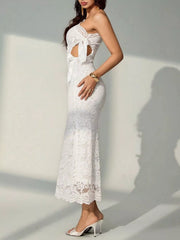 Side view of a white lace one shoulder midi dress showing the waist cutout and bows