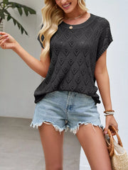 On-model front view of black openwork short sleeve knit top with heart shaped perforations outdoors