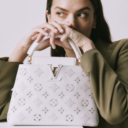a model holding a white louis vuitton bag