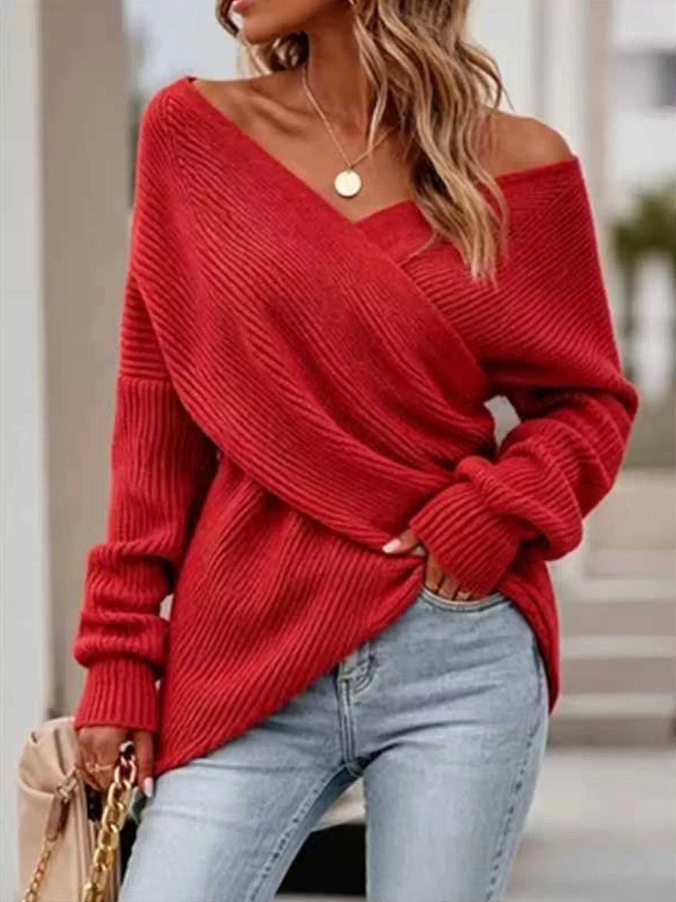 Front view of red ribbed knit sweater with crisscross V neckline and long sleeves.