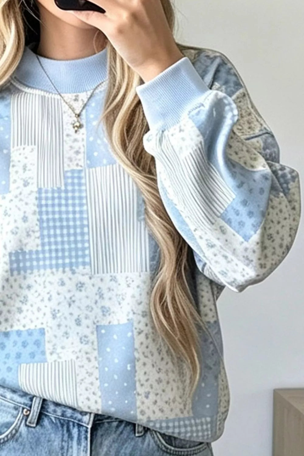 Close front detail of light blue vintage patchwork dropped shoulder sweatshirt showing mixed panels