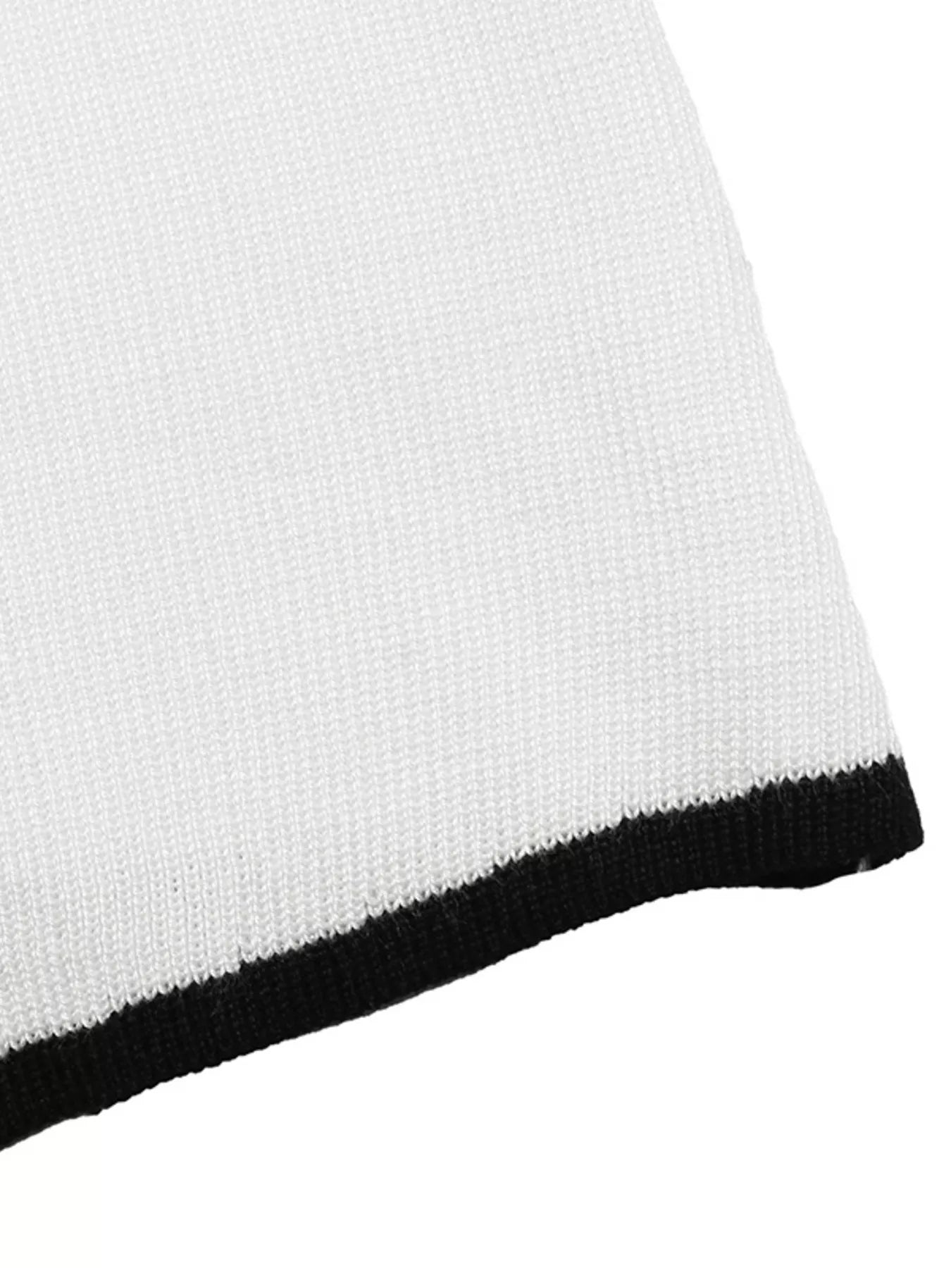 Close up of white knit fabric with black ribbed trim along the hem.