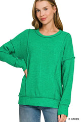 Bright green drop shoulder sweater with round neck and exposed seams, front view