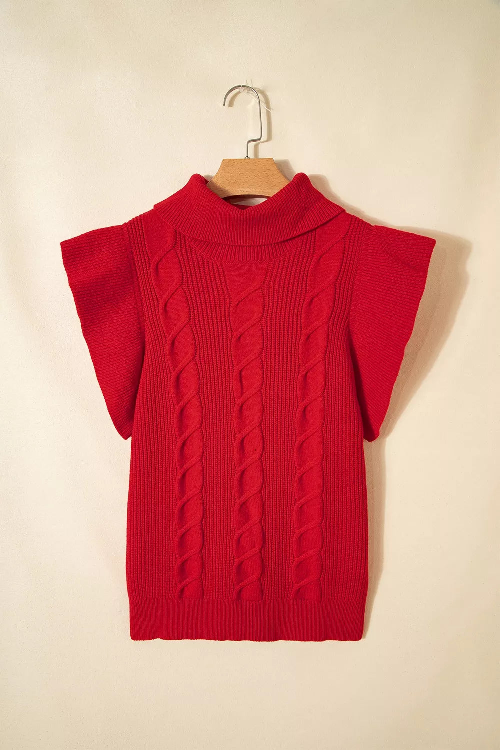 Hanging back view of a red cable knit turtleneck sweater with ruffled short sleeves