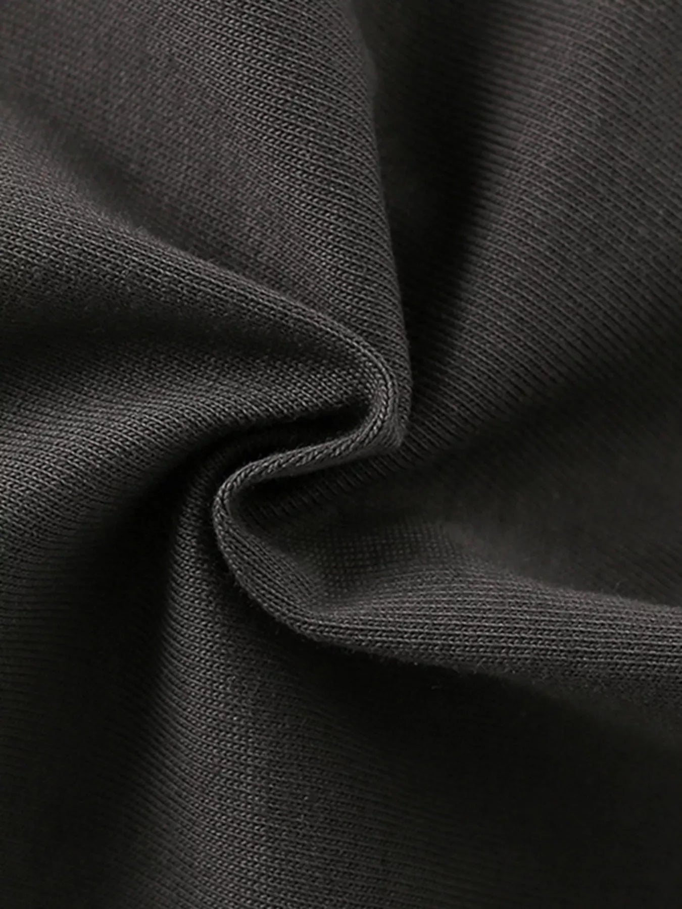 Close-up texture of the soft dark gray fabric of the children's short sleeve shirt