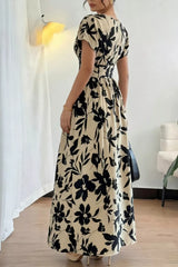 Back view of khaki floral short sleeve maxi dress with gathered waist and flared skirt