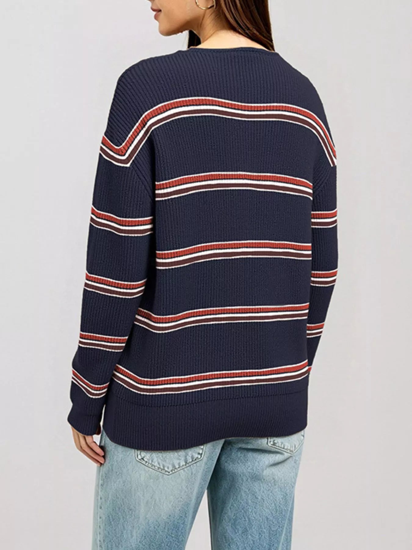 Back view of a dark blue striped ribbed knit top with long sleeves