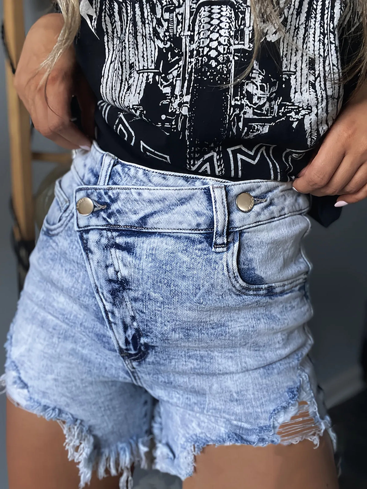 Women's light blue high-waisted denim shorts with distressed details and frayed hems.