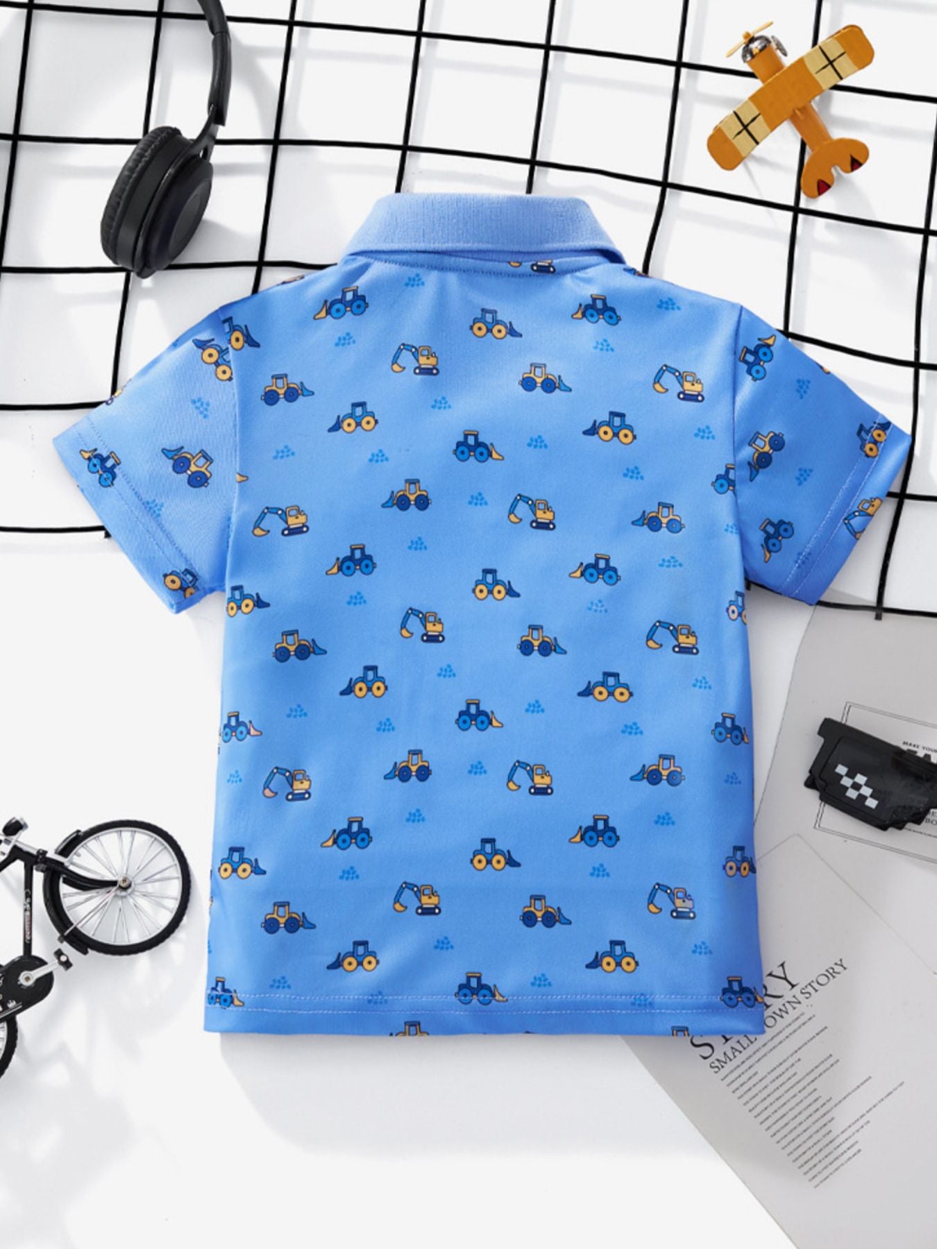 Back view of the blue children's short sleeve polo shirt with excavator print