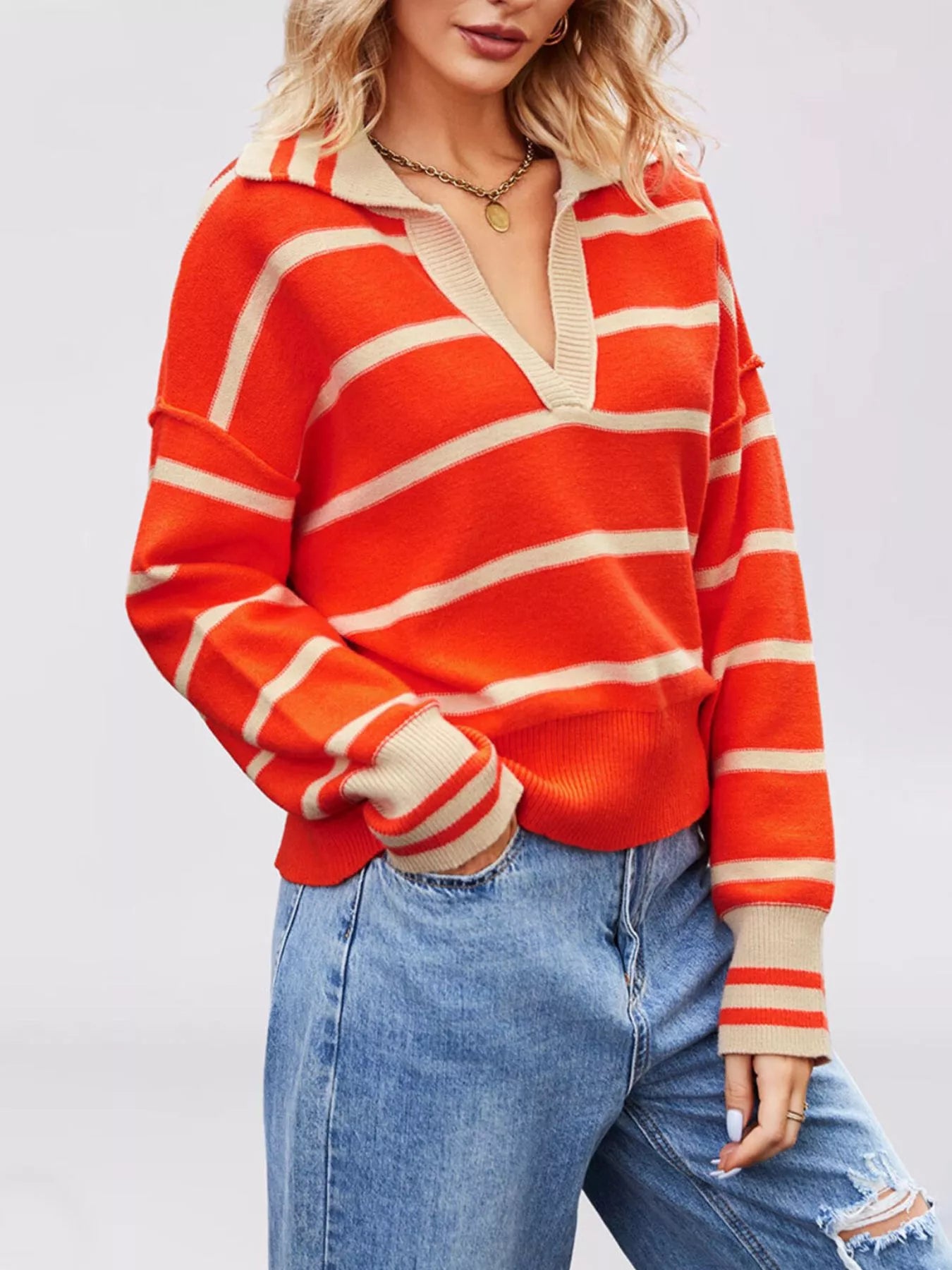 Angled on-model front view of orange red striped sweater with beige Johnny collar and dropped shoulders