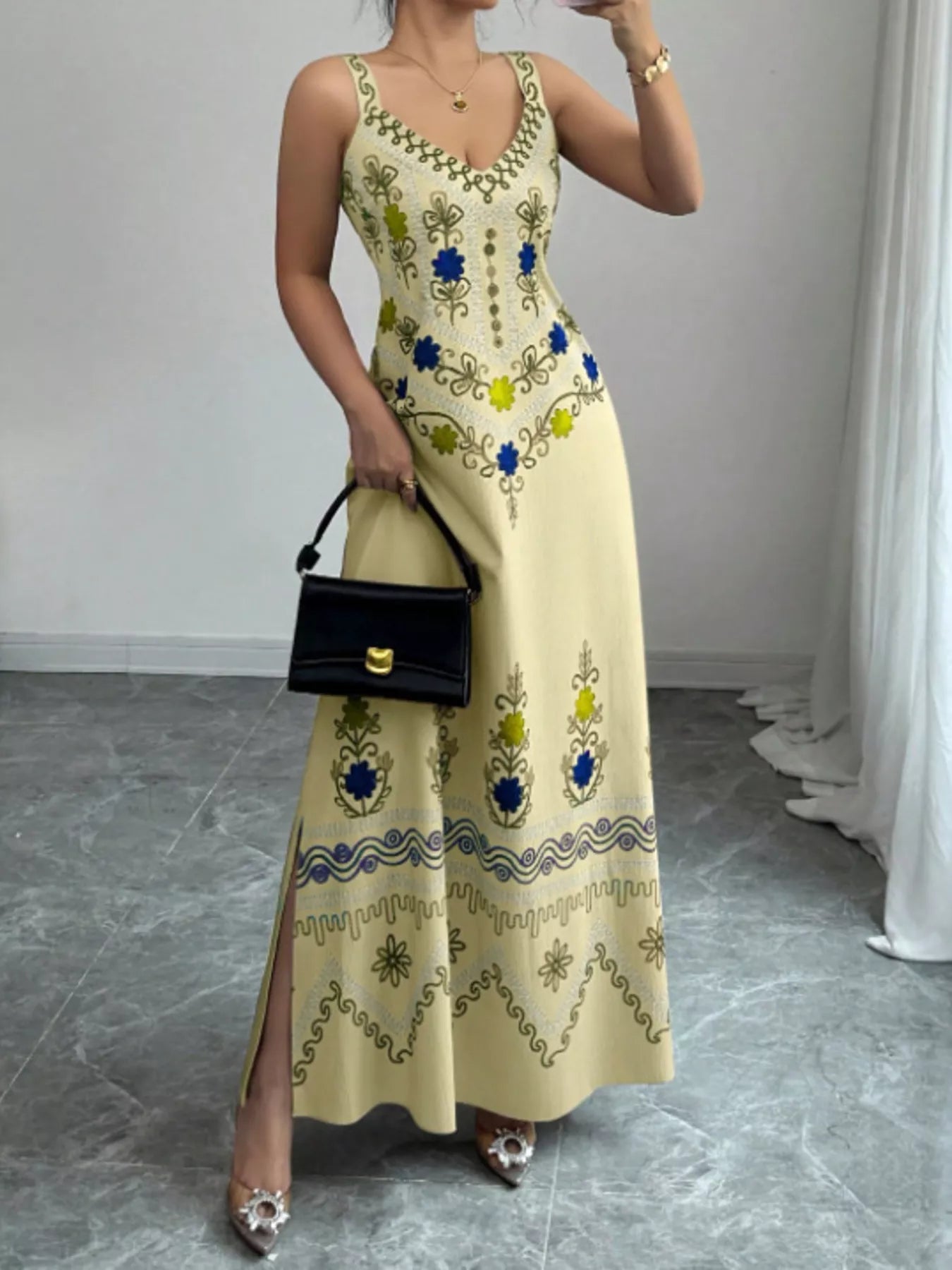 Pastel yellow floral sleeveless maxi dress with side slit shown from the front on model