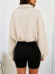Back view of apricot half zip sweatshirt with drawstring hem and relaxed fit