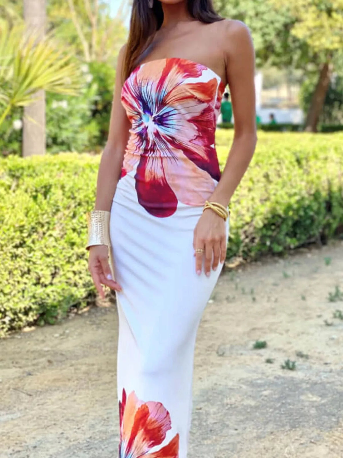 Strapless bodycon maxi dress with large red, pink and blue floral print, front view outdoors