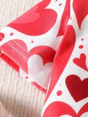 Close view of a short sleeve hem with stitching on a red and white heart print polo