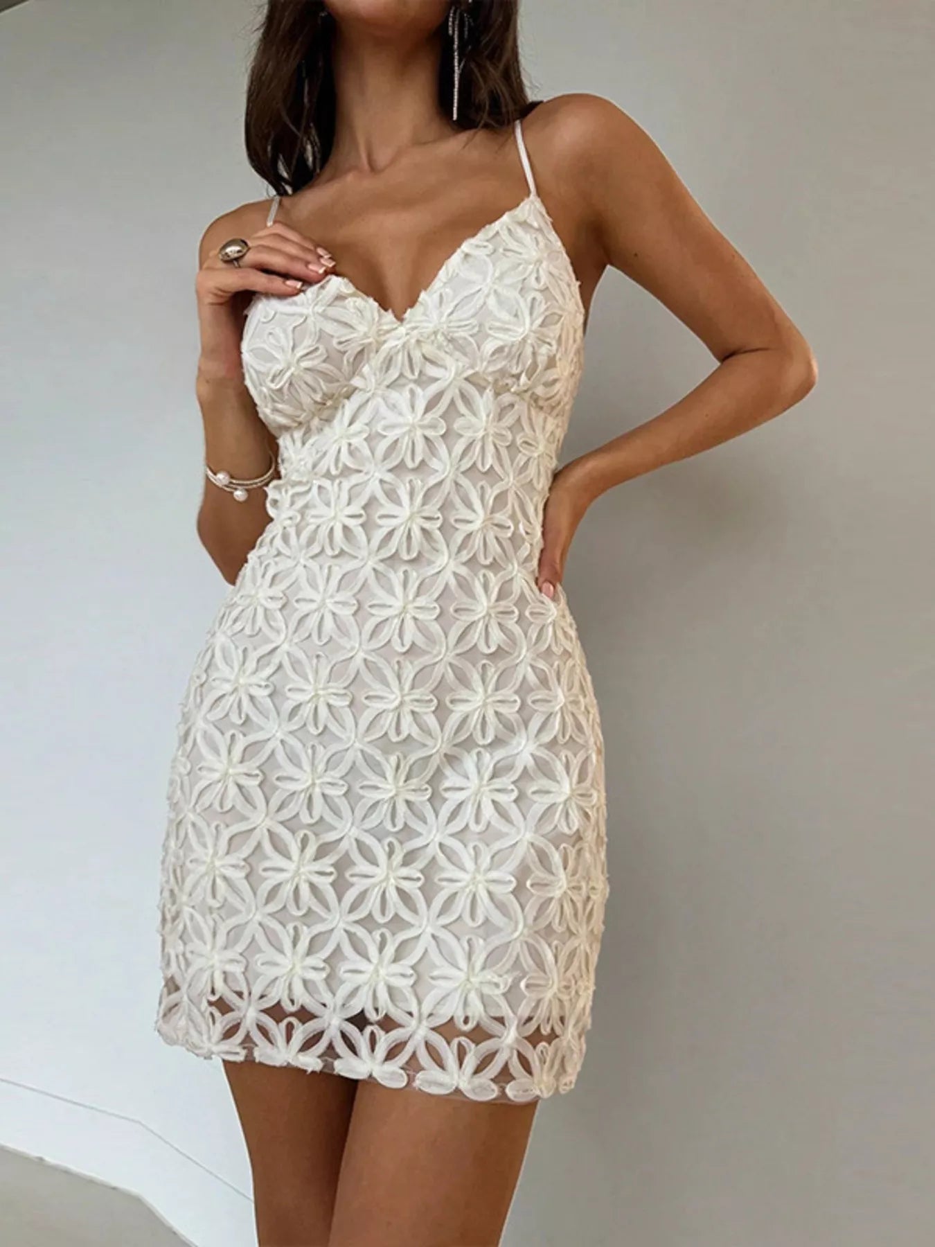 White floral lace bodycon mini dress, front view with hand near neckline
