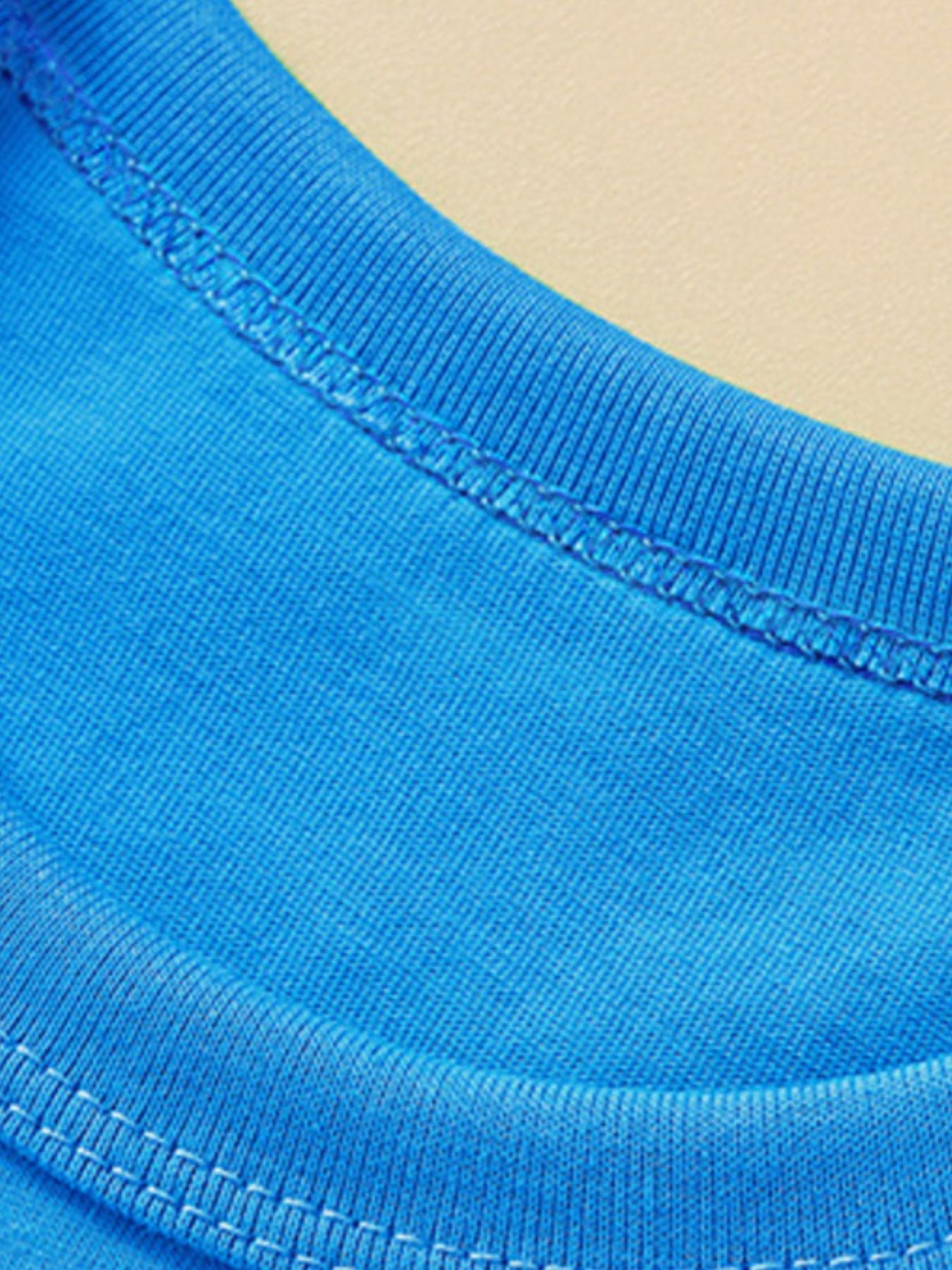 Close-up of the ribbed crew neckline and stitching on a sky blue children's t-shirt