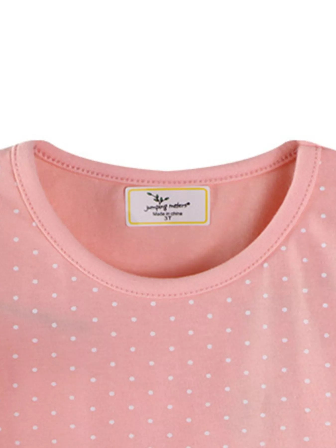Close view of the pale pink children's tee neckline showing neat stitching and polka dot fabric