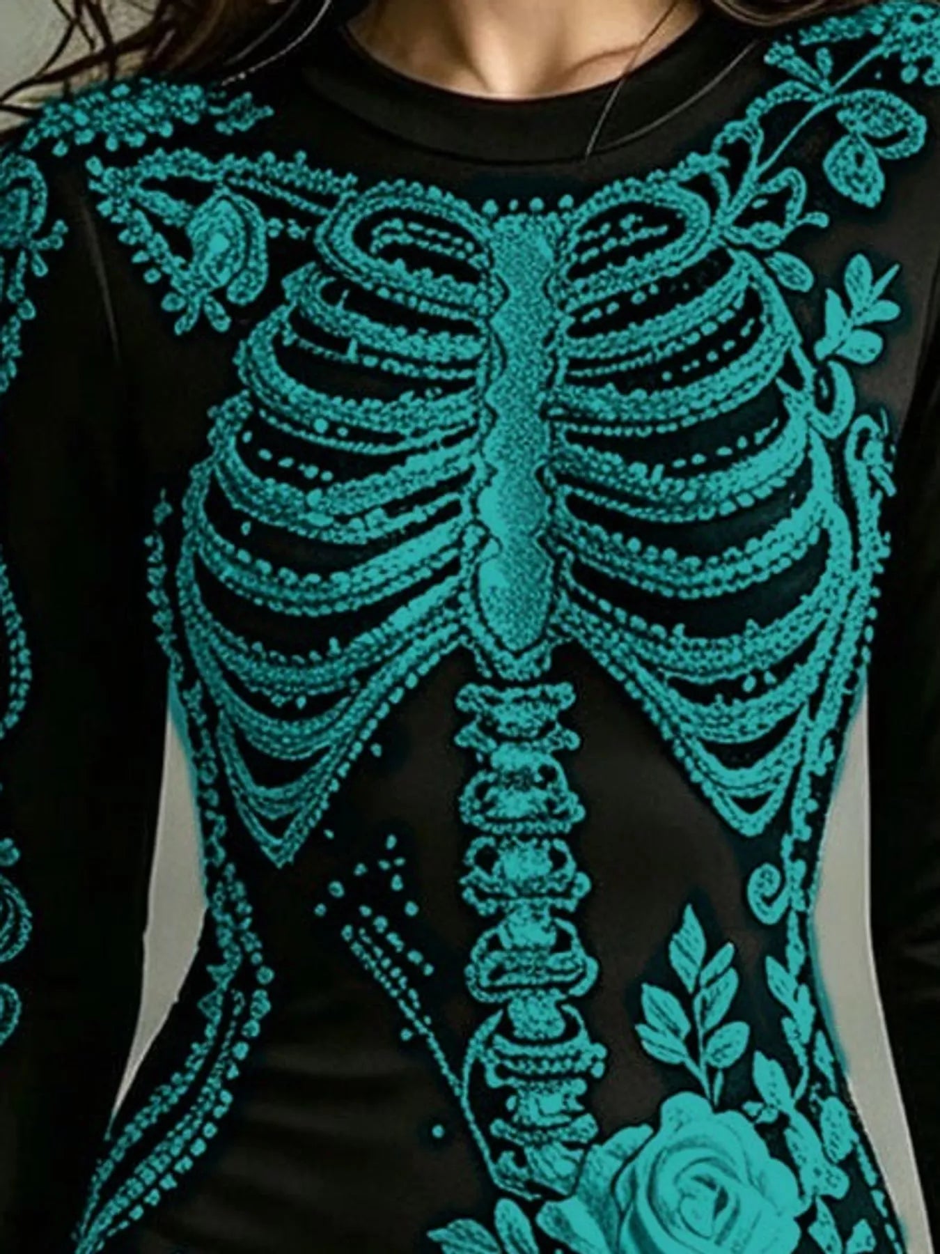 Close detail of teal skeleton print on black long sleeve bodycon dress bodice