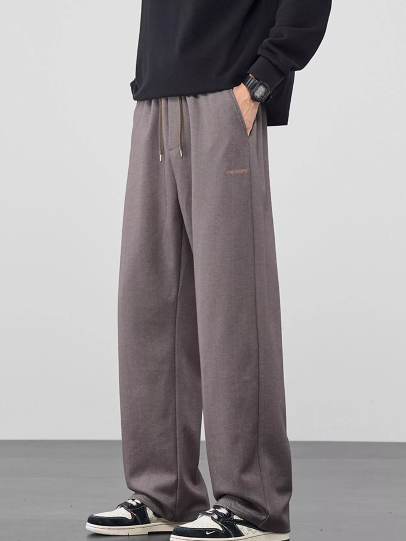 Men's mauve loose fit casual pants with a drawstring waist and pockets.