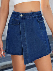 Women's denim skort with an asymmetrical shape and frayed hem.