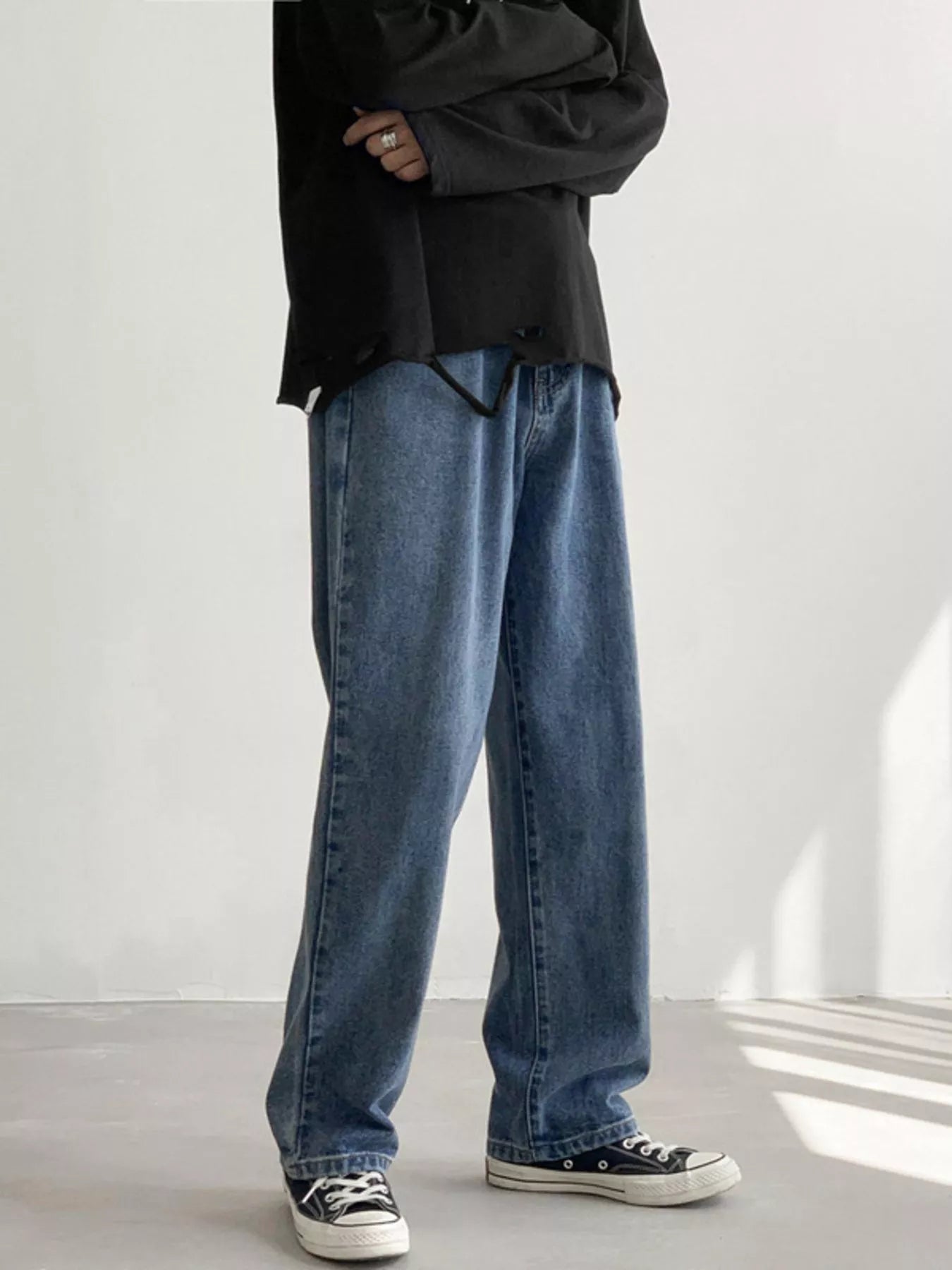 Men's Light Blue loose fit wash jeans on model, front view with arms crossed.