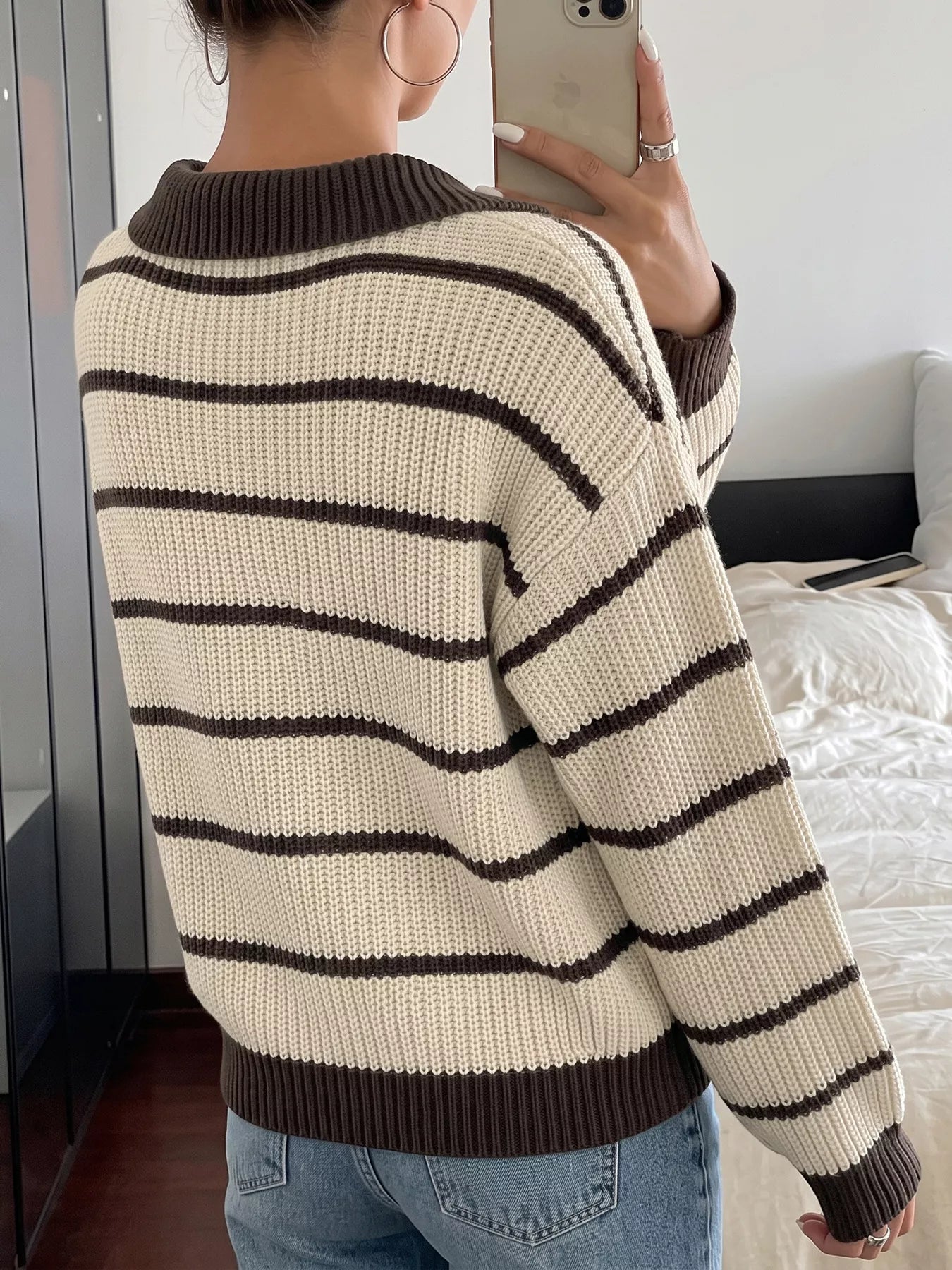 Back mirror view of a cream and brown striped knit polo sweater with long sleeves.