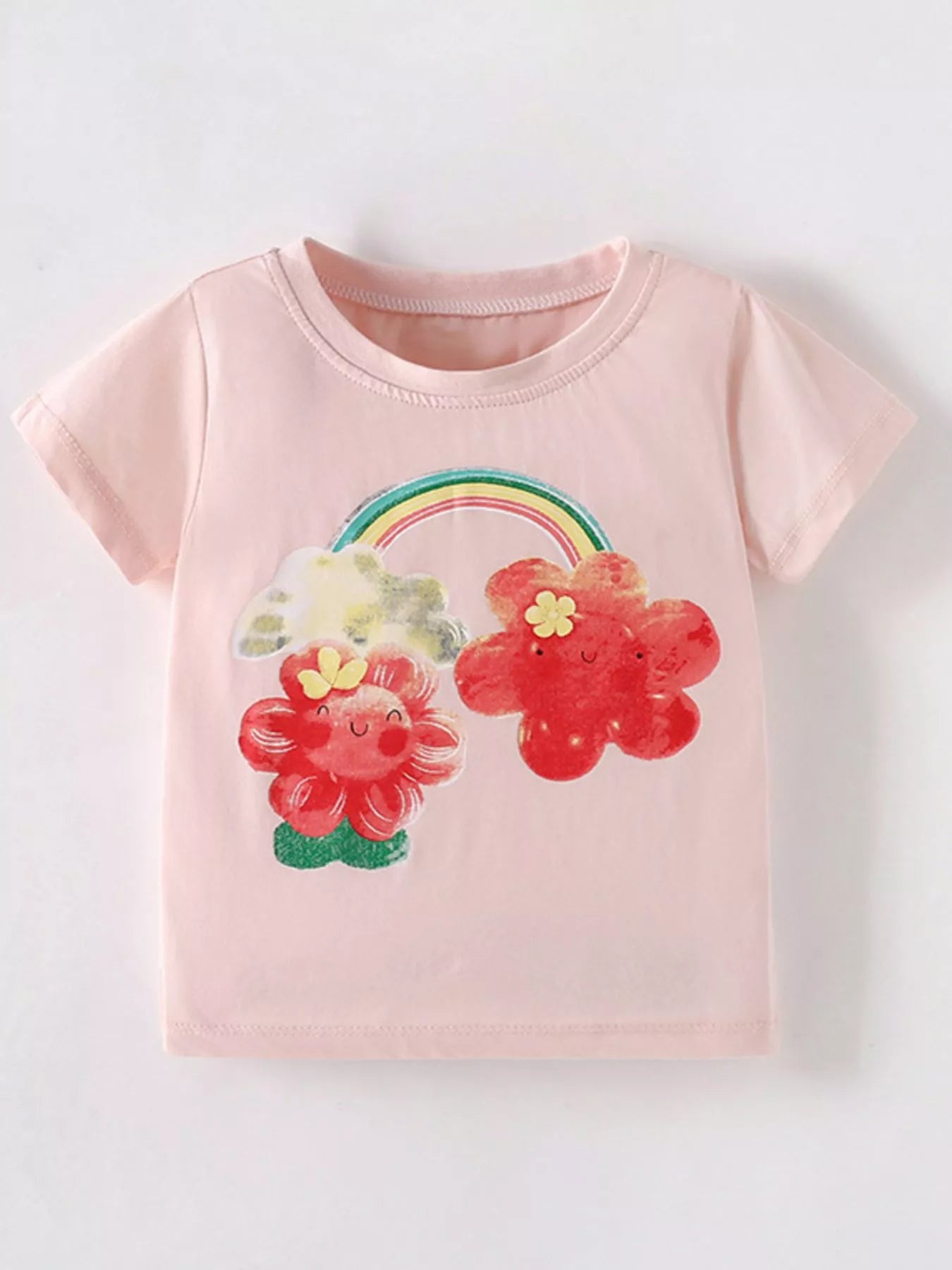 Front view of blush pink children's short sleeve tee with smiling red flowers and rainbow print