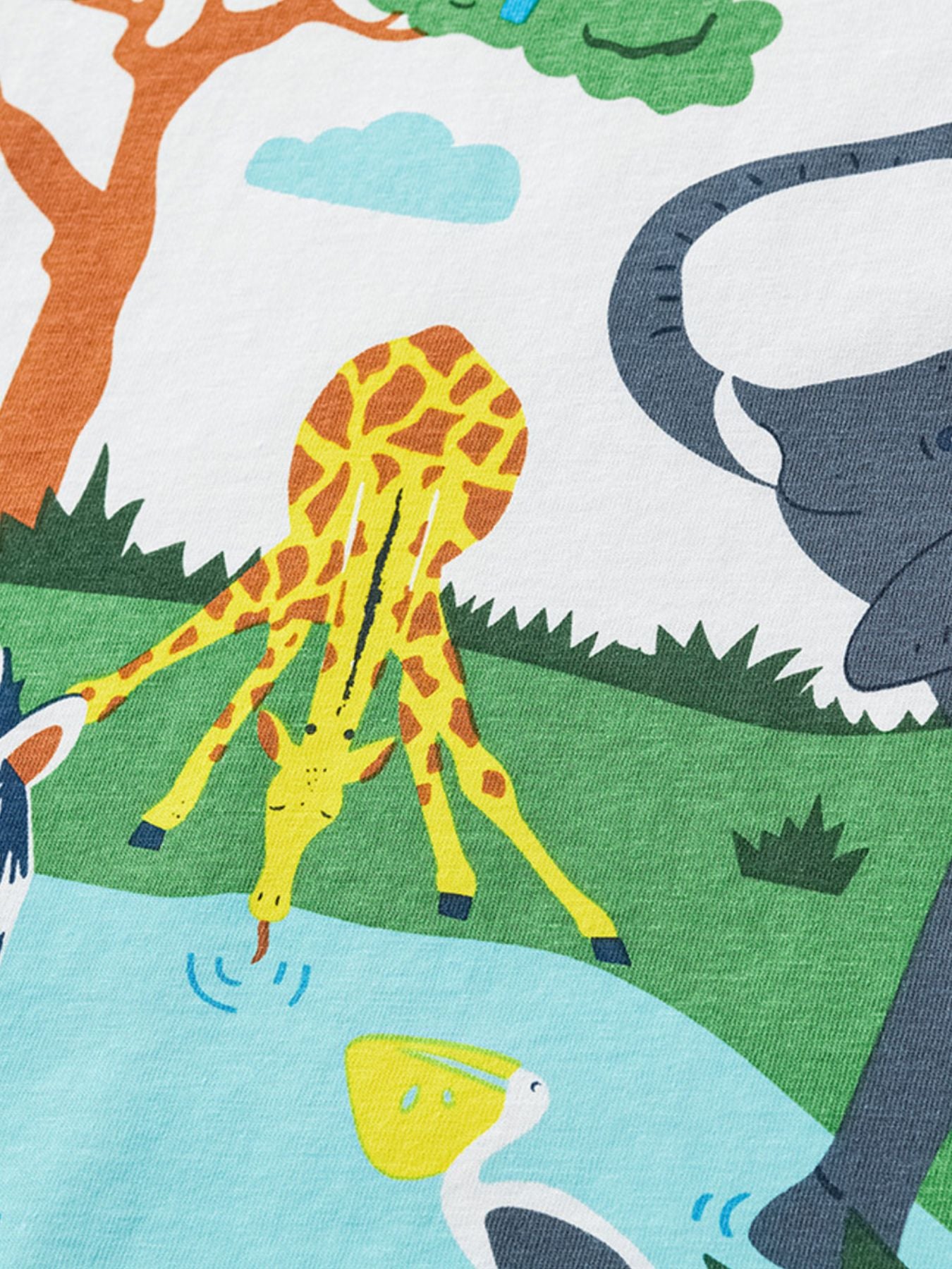 Close view of the giraffe drinking and elephant detail in the safari print on the white children's t-shirt