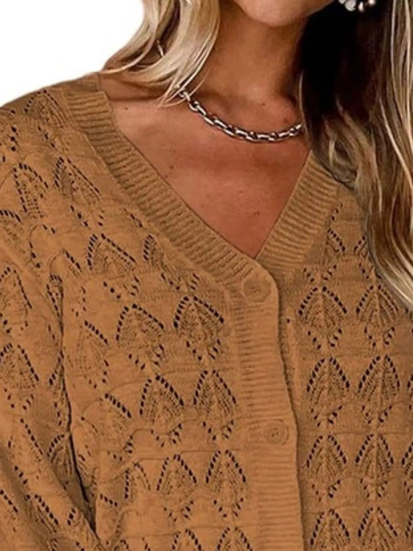 Close view of brown openwork knit cardigan showing V neckline and button front.